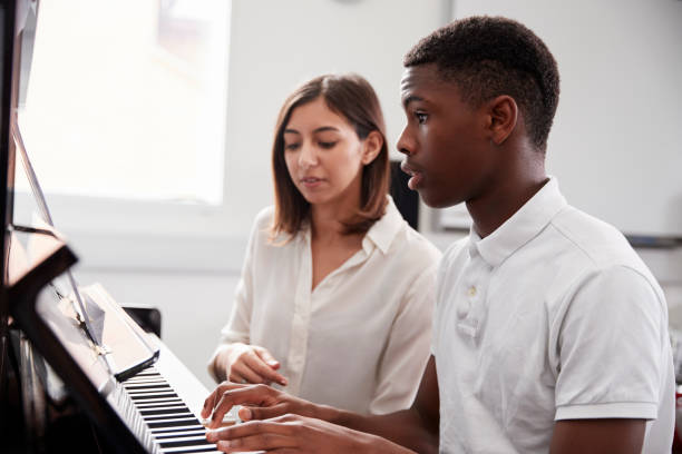 paino teacher and student sitting at a piano